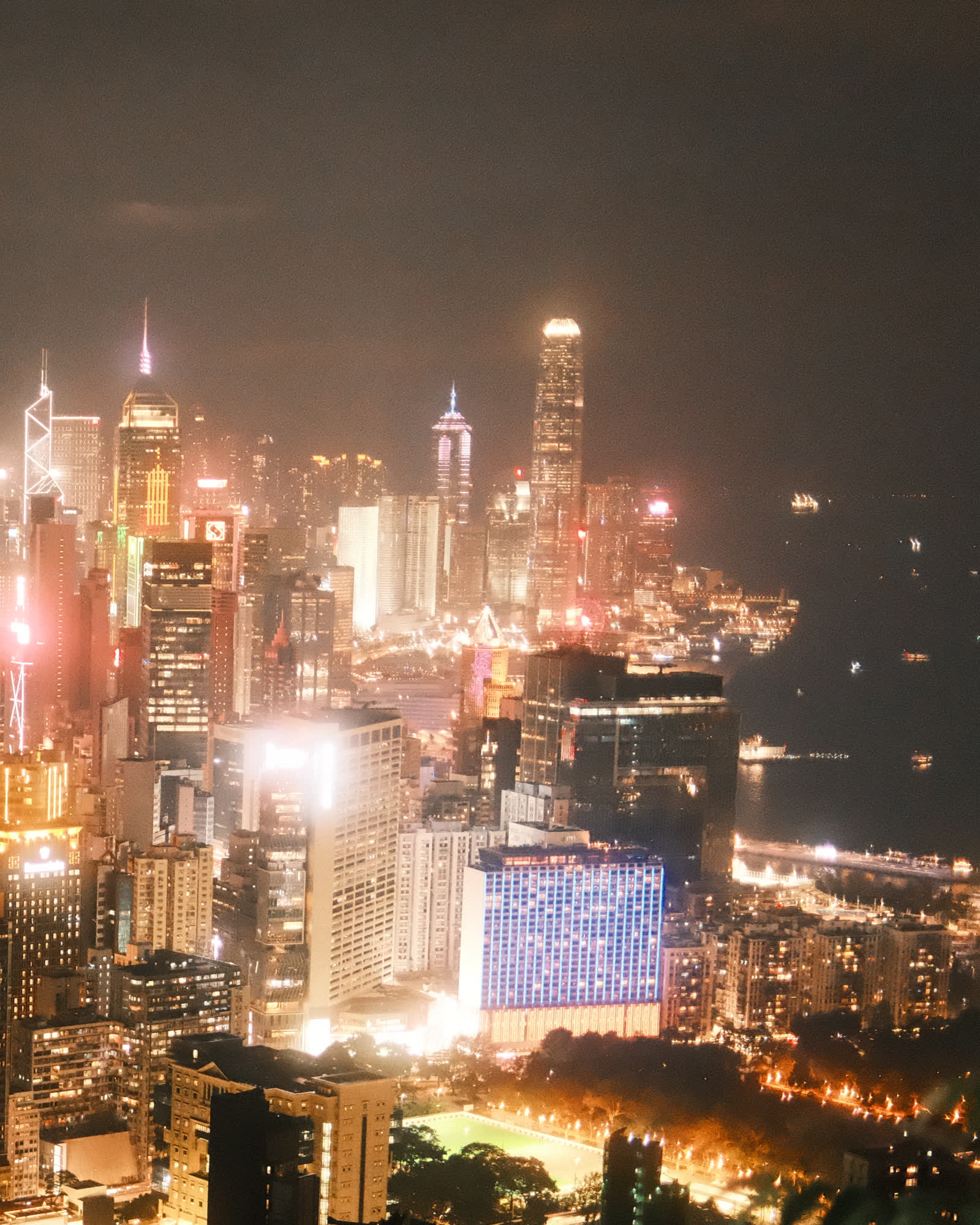 A city skyline at night, seen from a lookout above it.