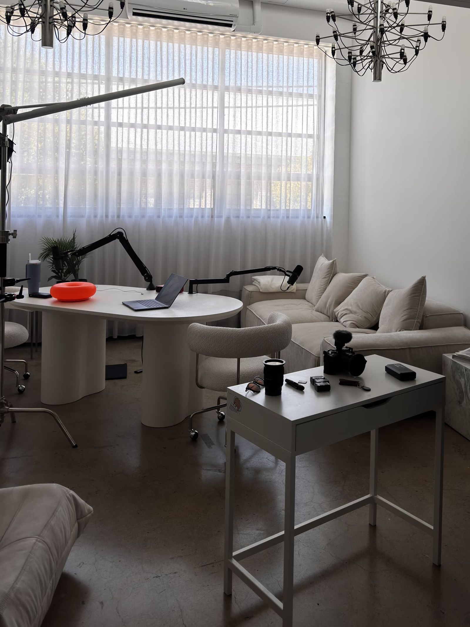 A studio set with C-stands and a camera on a table.